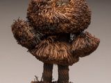 sculpture représentant un ours en peluche marron posé sur un socle noir