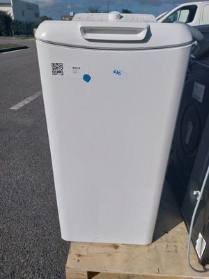 un réfrigérateur blanc posé sur une palette à côté d'une voiture