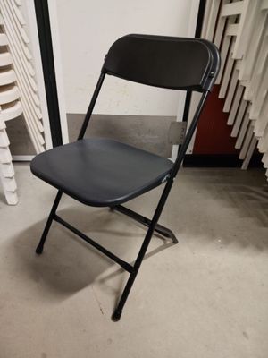 a black folding chair sitting in front of a radiator