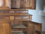 a wooden cabinet with a door open on a tiled floor