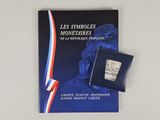books on a white table with a blue cover and a red, white, and blue ribbon
