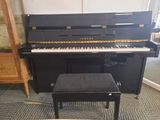a black piano and a stool in a room