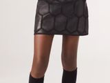 a woman in a skirt and jacket posing for a picture