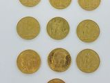 six types différents de pièces d'or sur une surface blanche