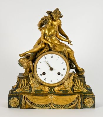 une horloge en or surmontée d'une statue