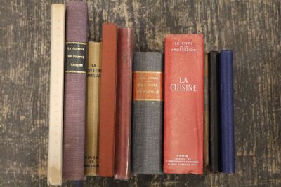 plusieurs vieux livres sont alignés sur une table en bois