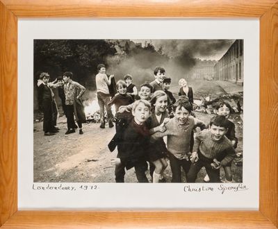 a picture of a group of children that are standing in front of a fire