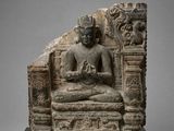 a stone statue of a seated buddha on a platform
