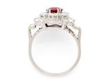 a close up of a diamond and ruby ring on a white background