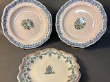 three plates with floral designs on them sitting on a table
