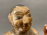 a wooden statue of a man holding a hot dog