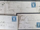 three envelopes with stamps on them sitting on a wooden table