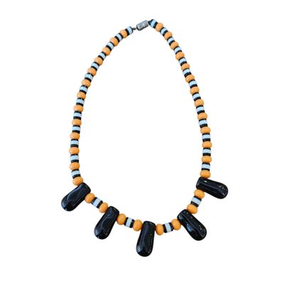 un gros plan sur un collier composé de perles noires et orange