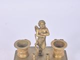 brass figurine of a man holding a cup and a candle