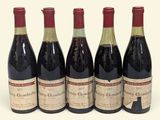 four bottles of wine are lined up on a white surface