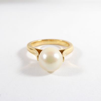 gros plan d'une bague en perle sur une surface blanche