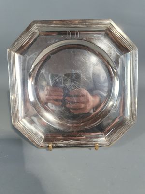an image of a silver plate with a picture of a man holding a camera
