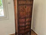 une commode dans un coin d'une chambre où se trouve un lit