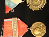 several medals are displayed on a black surface with a red, white, and blue ribbon