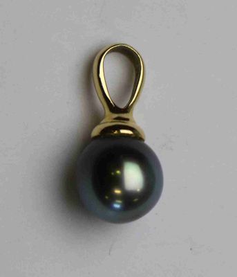 une image représentant un pendentif en perle noire posé sur une surface blanche