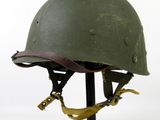 an old helmet on a stand on a white background