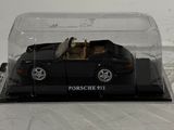 a black toy car in a glass case on a table