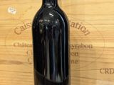 a bottle of red wine sitting on a wooden table