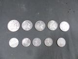 Plusieurs pièces d'argent de 25 centimes sont alignées sur une table