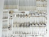 un grand nombre de cuillères et de fourchettes en argent disposées sur une table