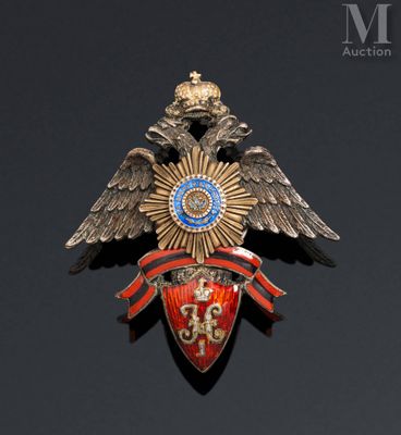 an image of a gold and red broochle with an eagle on it