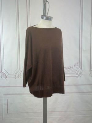 brown sweater on a mannequin stand in front of a white wall