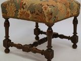 a small foot stool with a floral upholstered seat