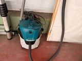 an image of a vacuum and a hose in a garage