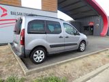 a small silver van parked in front of a building