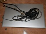 a silver laptop with a black headphone on top of it