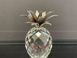 un ananas en cristal posé sur une table en verre