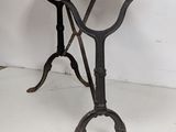 a small table with a marble top and iron legs
