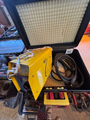 un poste à souder jaune posé dans un coffret au sol