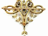 a close up of a brooch with a black stone in it