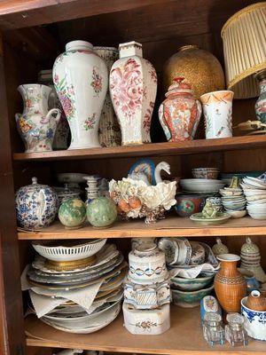 Il y a toutes sortes de vases et d'assiettes sur cette étagère