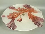 a glass plate with a flower on it on a table