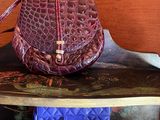 a purple purse sitting on a shelf next to a blue purse