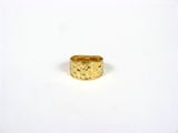 une bague en or posée sur une surface blanche, avec un fond blanc