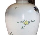 a white vase with a red flower on it