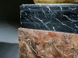 a close up of a marble column with a gold base