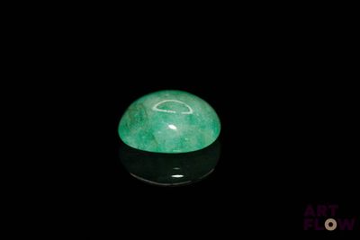 an image of a green jade ball on a black surface