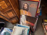 a pile of books on the floor next to a dresser