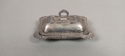 un vieux plat en argent avec un couvercle en argent posé sur une table