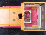 a yellow and pink toy truck with a red door