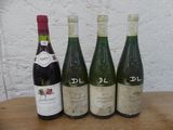 quatre bouteilles de vin sont alignées sur une table